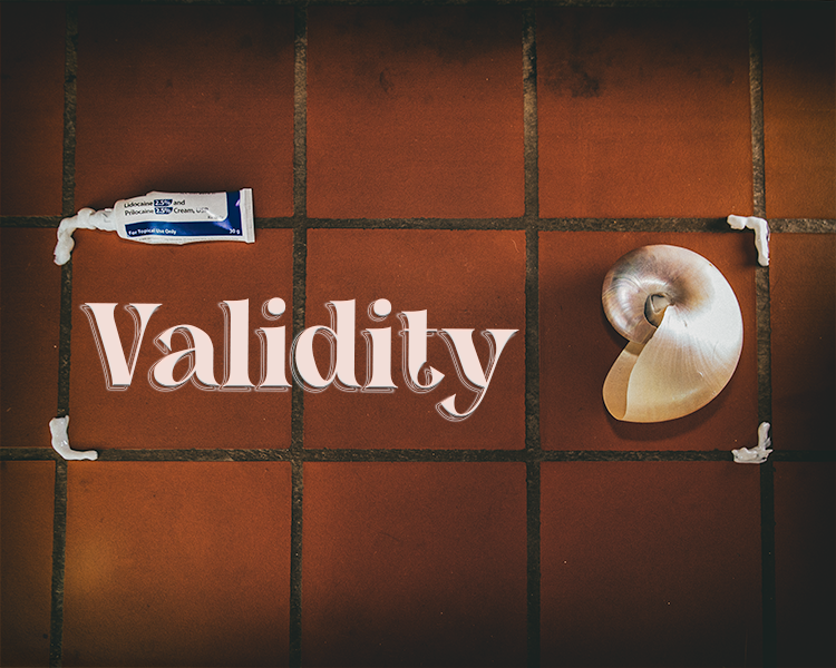 A nautilus shell is placed to the edge of the image and a bottle of prescription lidocaine cream sits aligned on the opposite side. The medication cream is used to make a frame where both the shell and text overlay 'Validity' is placed.